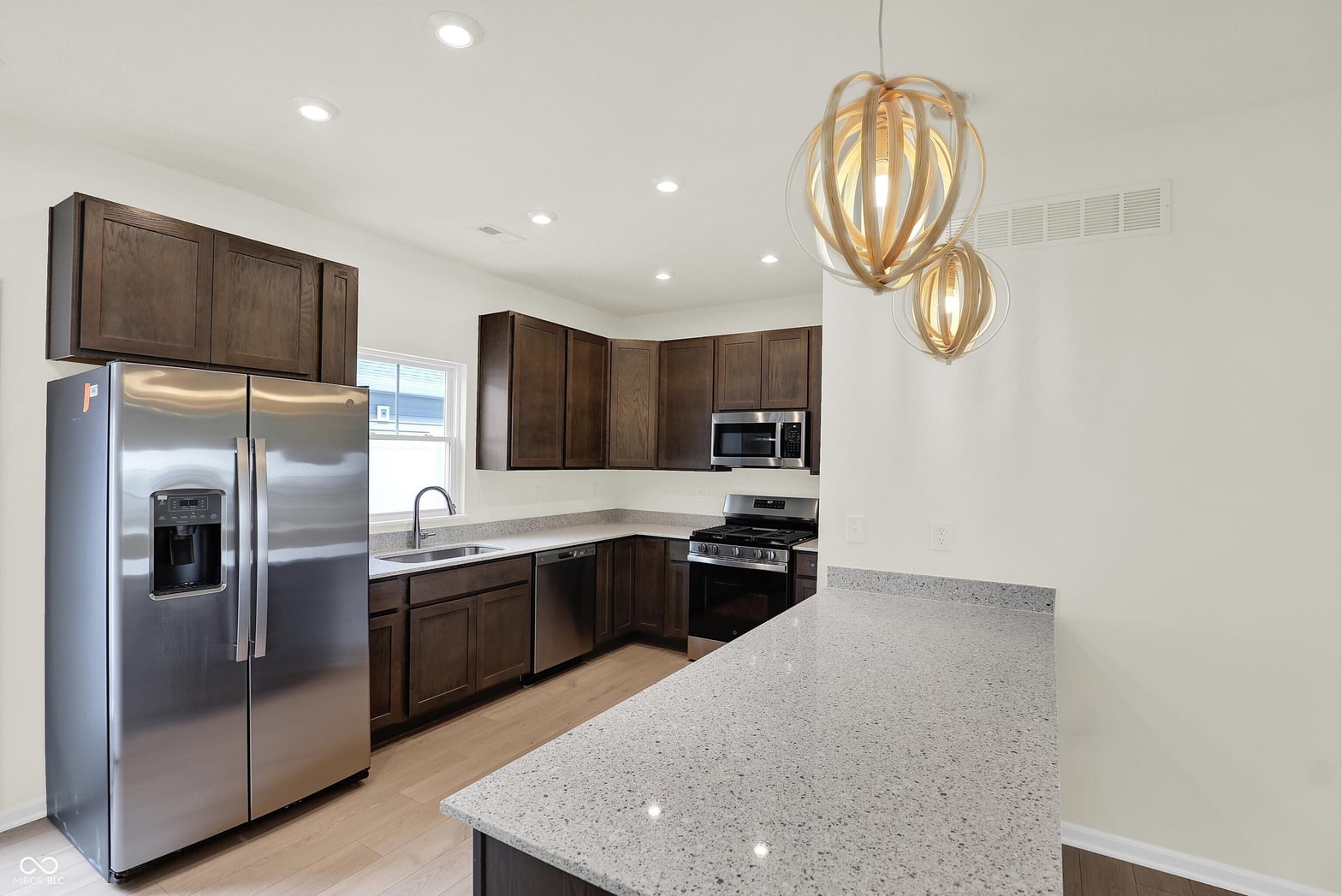 Modern kitchen with stainless steel and quartz countertops.