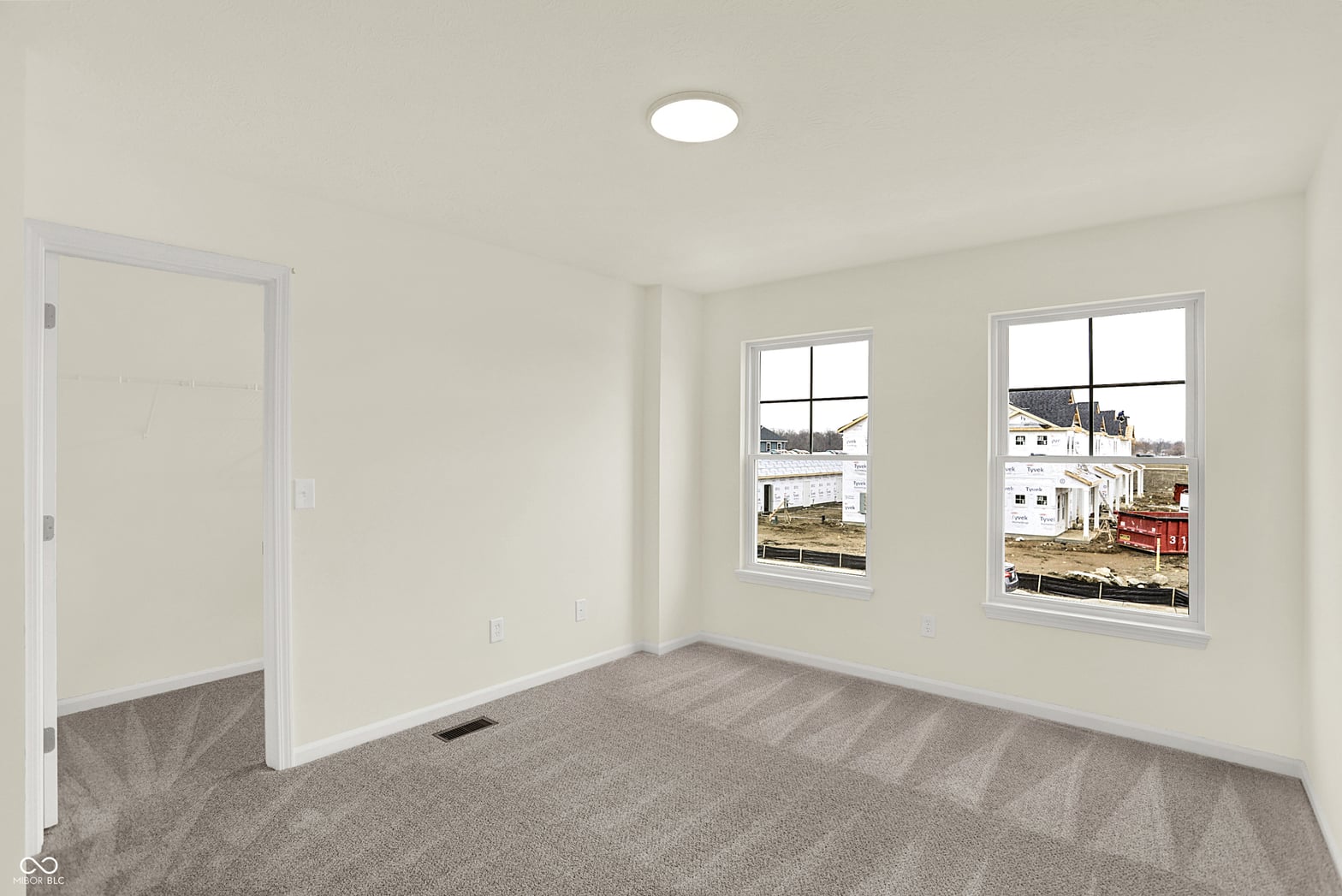 Bright bedroom with large windows and recessed lighting.