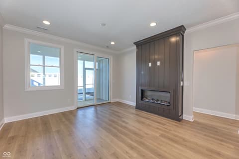Living room at 2412 N Keenan Circle, Westfield, IN — Modern living space with fireplace and balcony access.