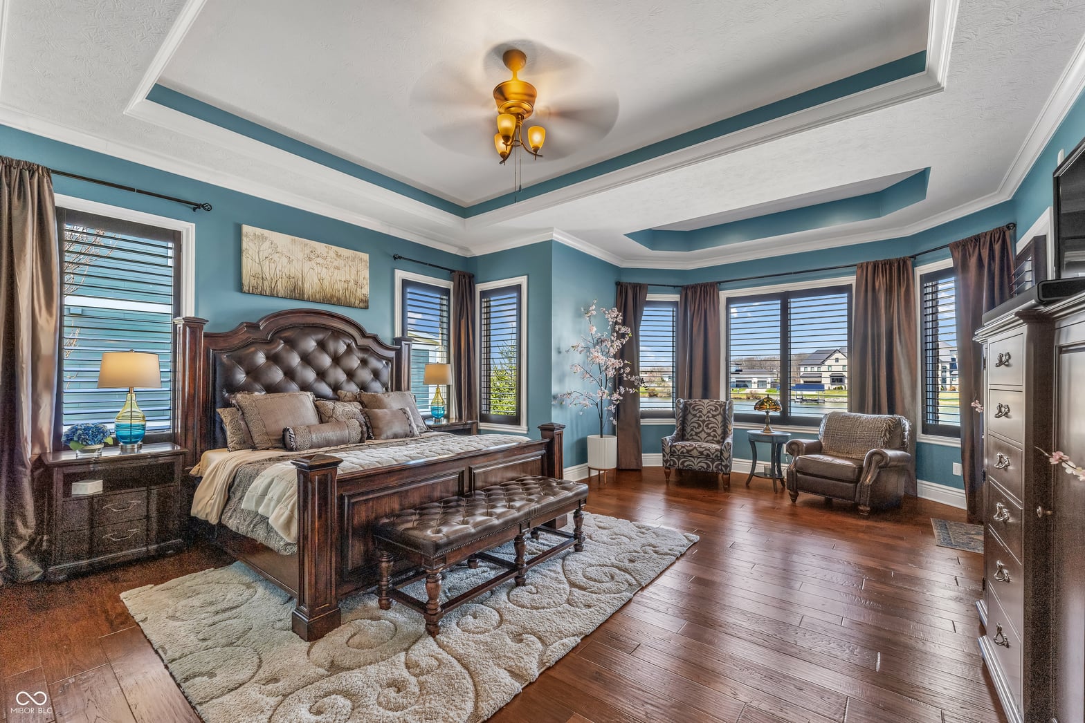 Luxurious primary suite with coffered ceiling and panoramic views.