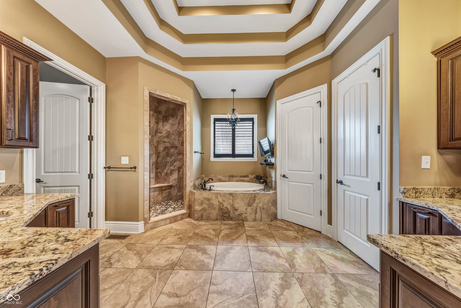 Luxurious primary bath with soaking tub and dual vanities.