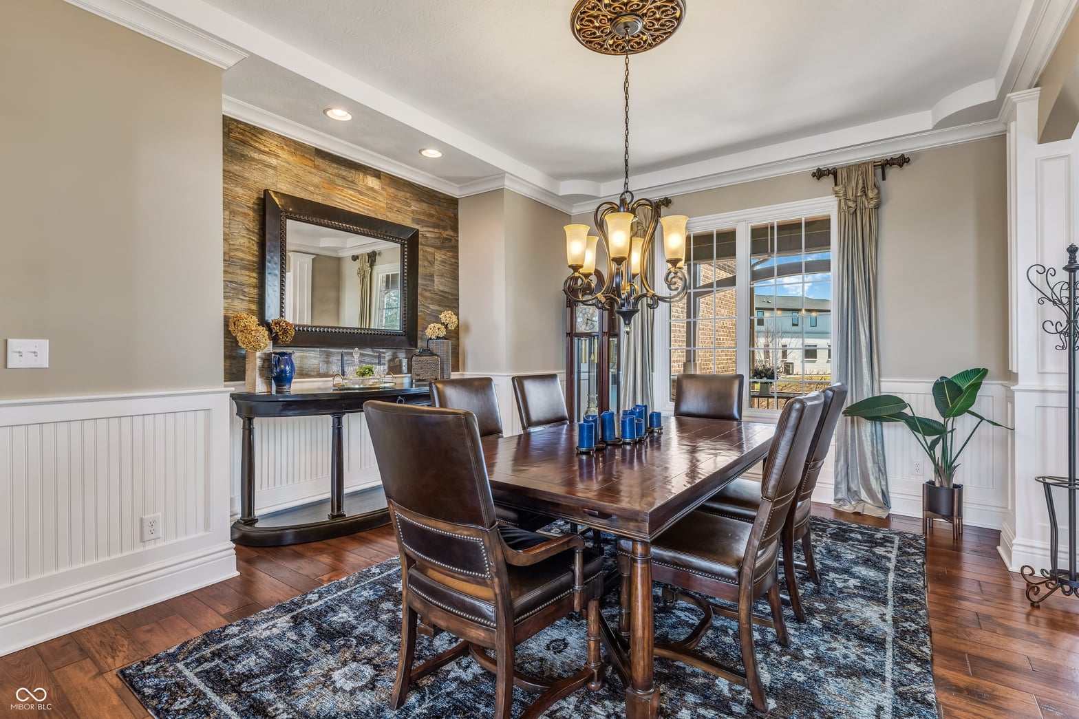 Elegant dining room with stone accent wall and chandelier.