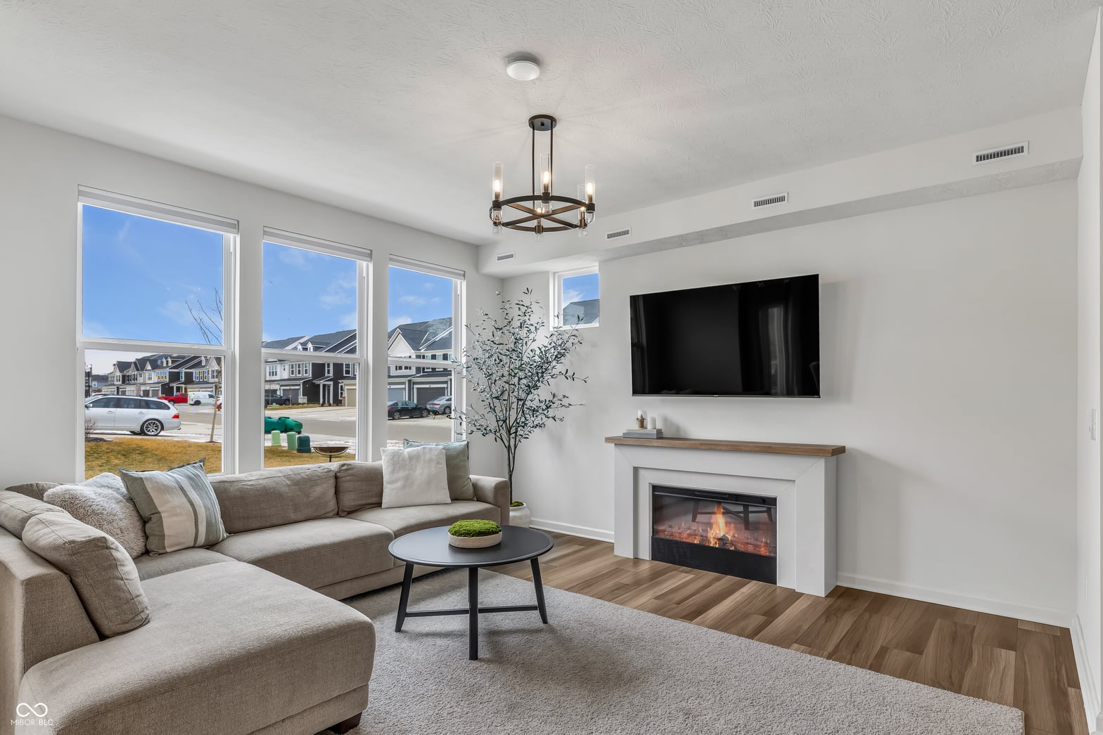 Bright modern living room with fireplace and street views.