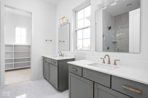 Primary bathroom at 17338 Ditch Road, Westfield, IN — Spa-like primary bath with dual vanity and walk-in closet.