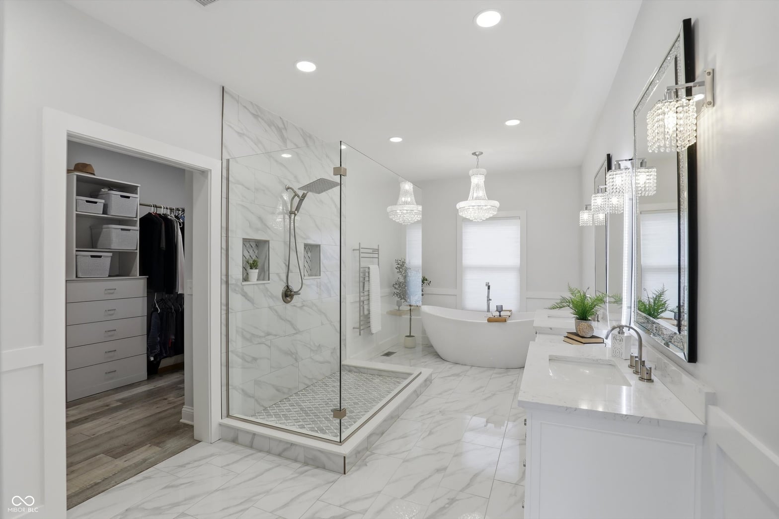 Luxurious primary bath with marble, soaking tub, and dual vanity.