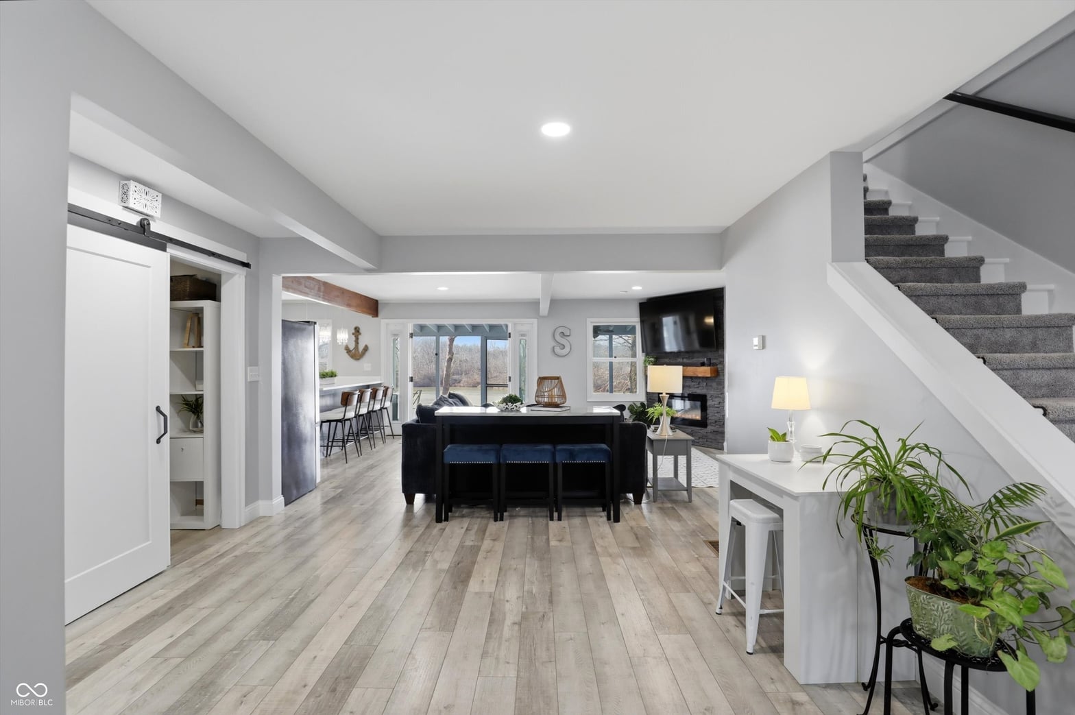 Modern open-concept living space with fireplace and island.