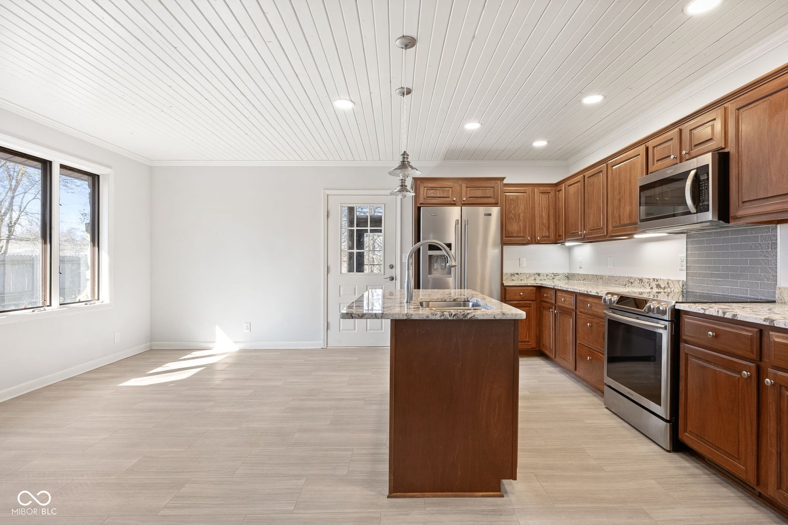 Bright, spacious kitchen with wood cabinetry and island.