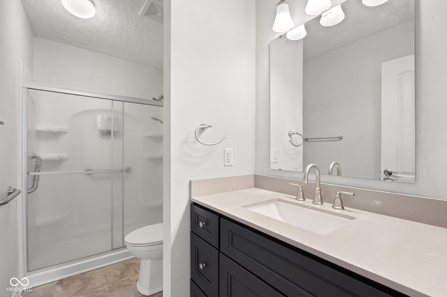 Luxe primary bath with double vanity and frameless shower.