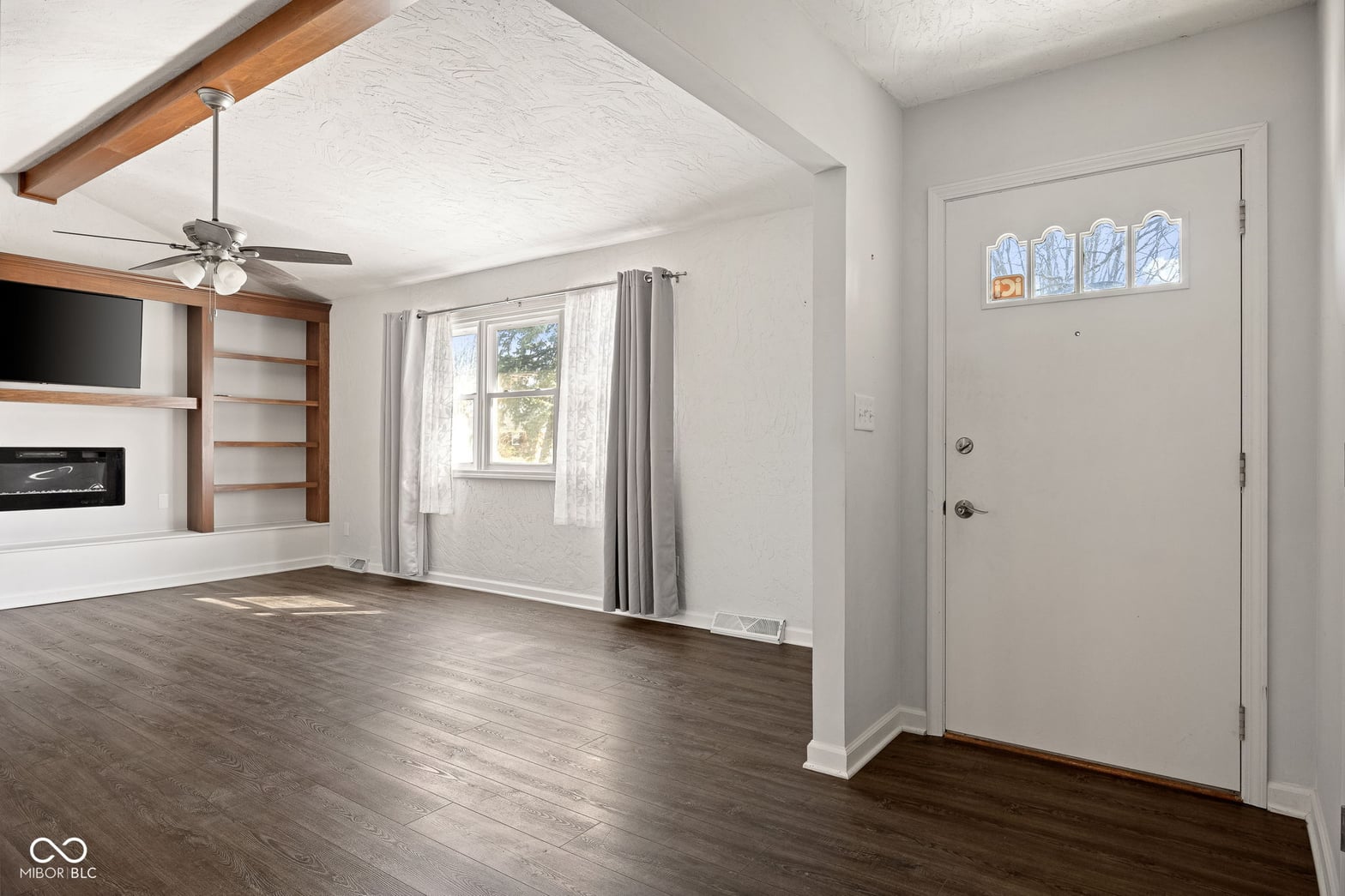 Bright living room with exposed beams and fireplace.