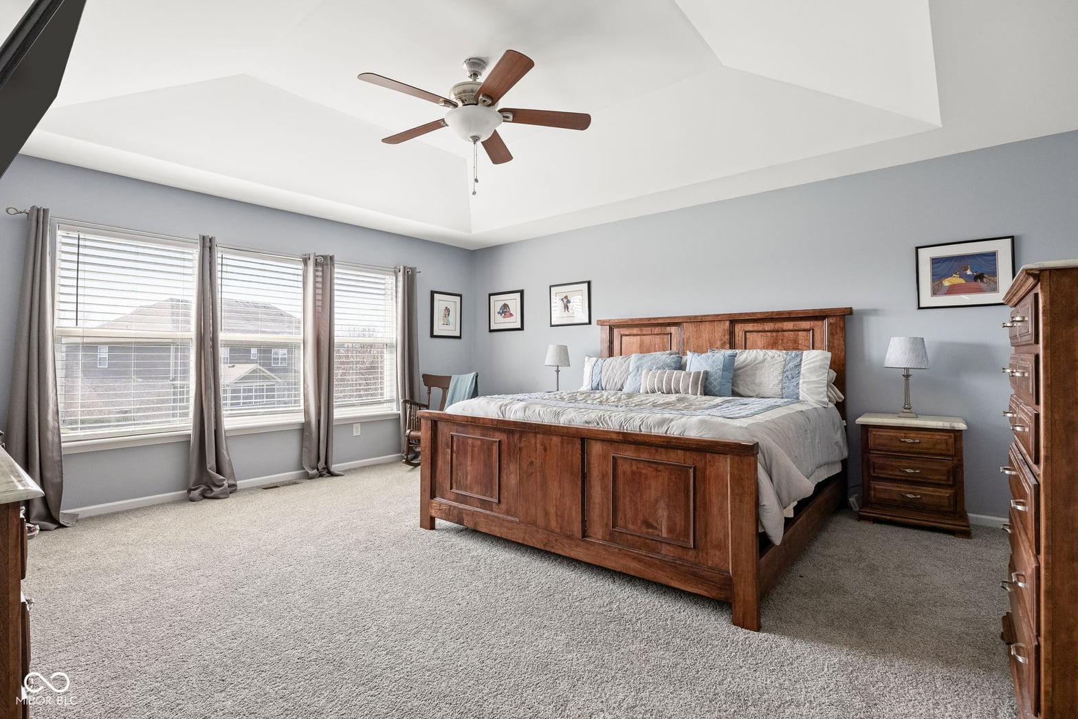 Spacious primary bedroom with tray ceiling and abundant natural light.
