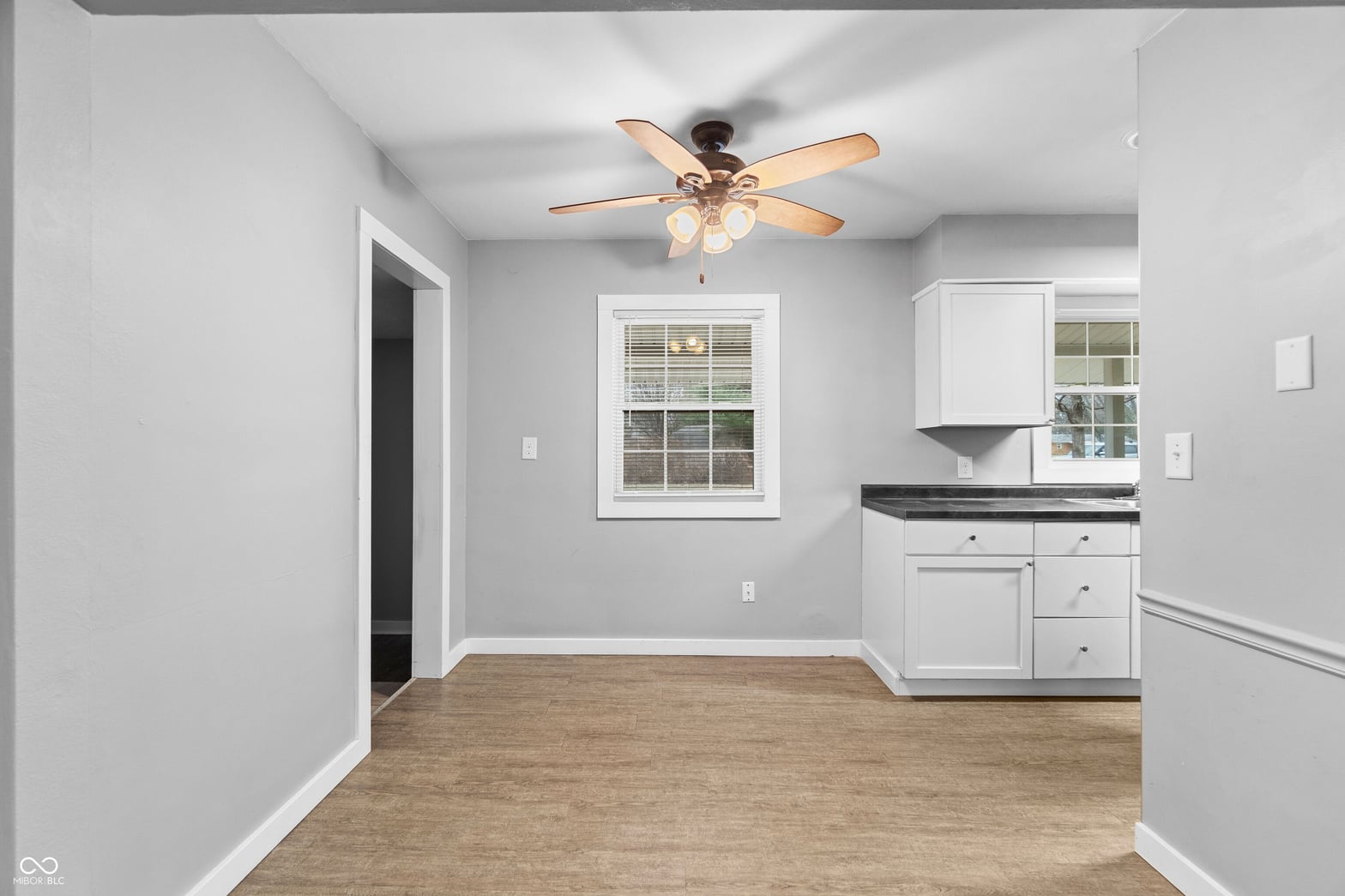 Updated kitchen with white cabinetry and hardwood floors.