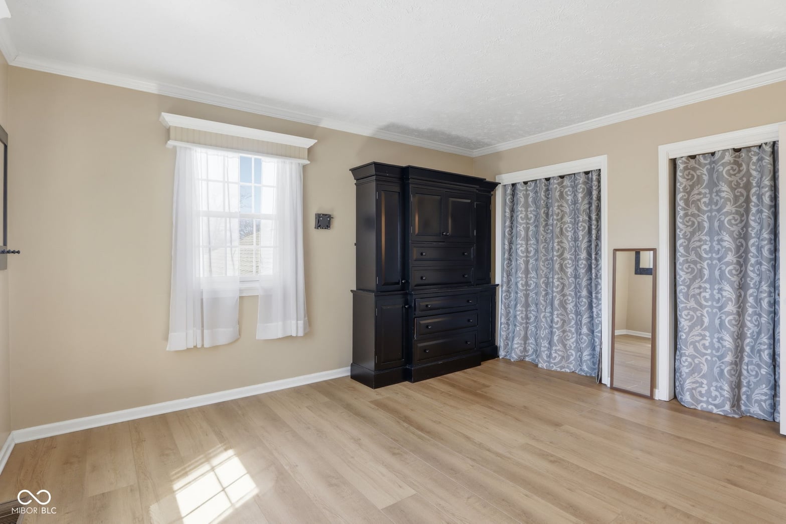Spacious primary bedroom with hardwood floors and natural light.
