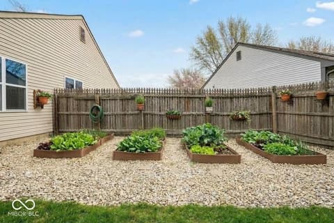 Yard at 450 E Pine Ridge Drive, Westfield, IN — Spacious fenced yard with organized raised garden beds.