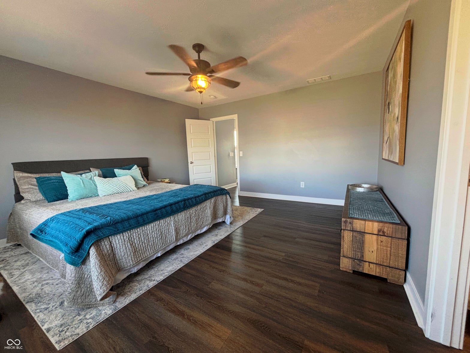 Spacious primary bedroom with hardwood floors and modern finishes.