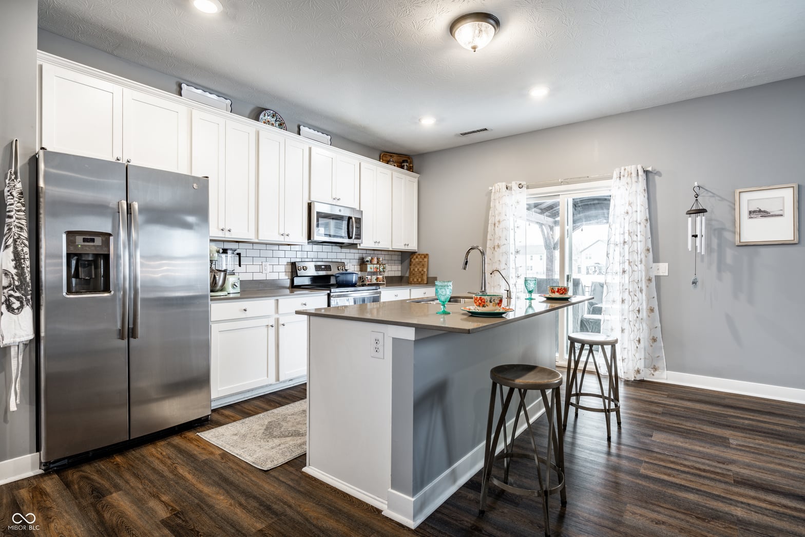 Bright renovated kitchen with island and stainless steel appliances.