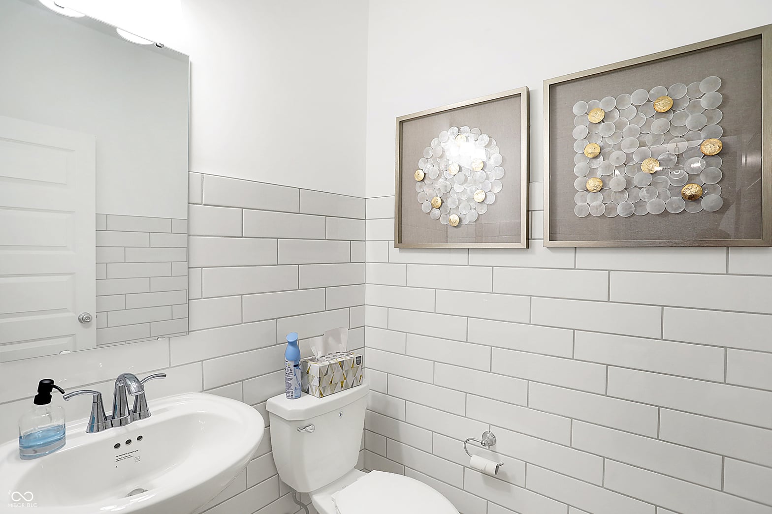 Bright, updated bathroom with stylish subway tile and framed artwork.