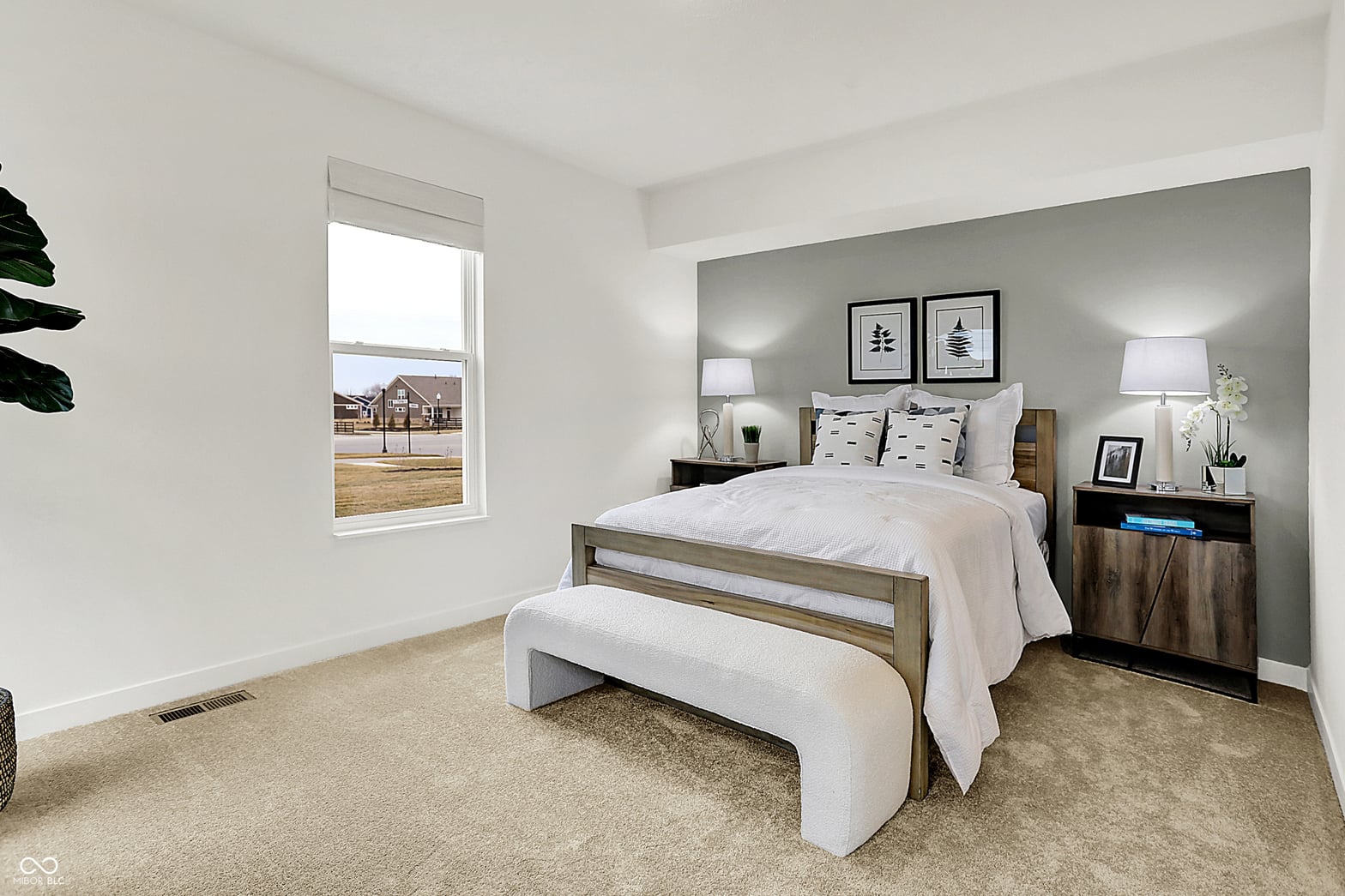 Bright primary bedroom with accent wall and modern furnishings.