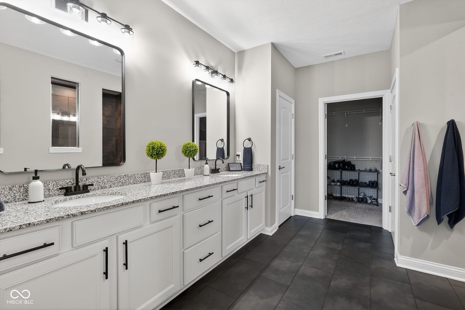 Luxurious primary bath with dual vanity and granite counters