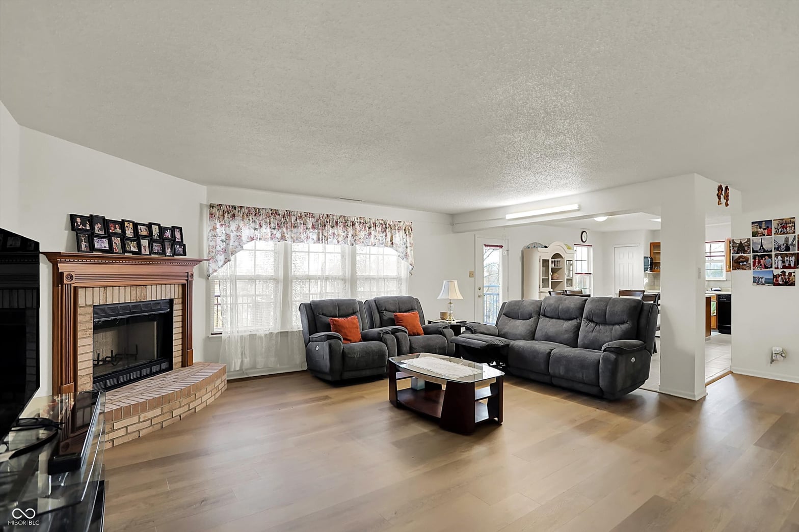Spacious living room with fireplace and hardwood floors.