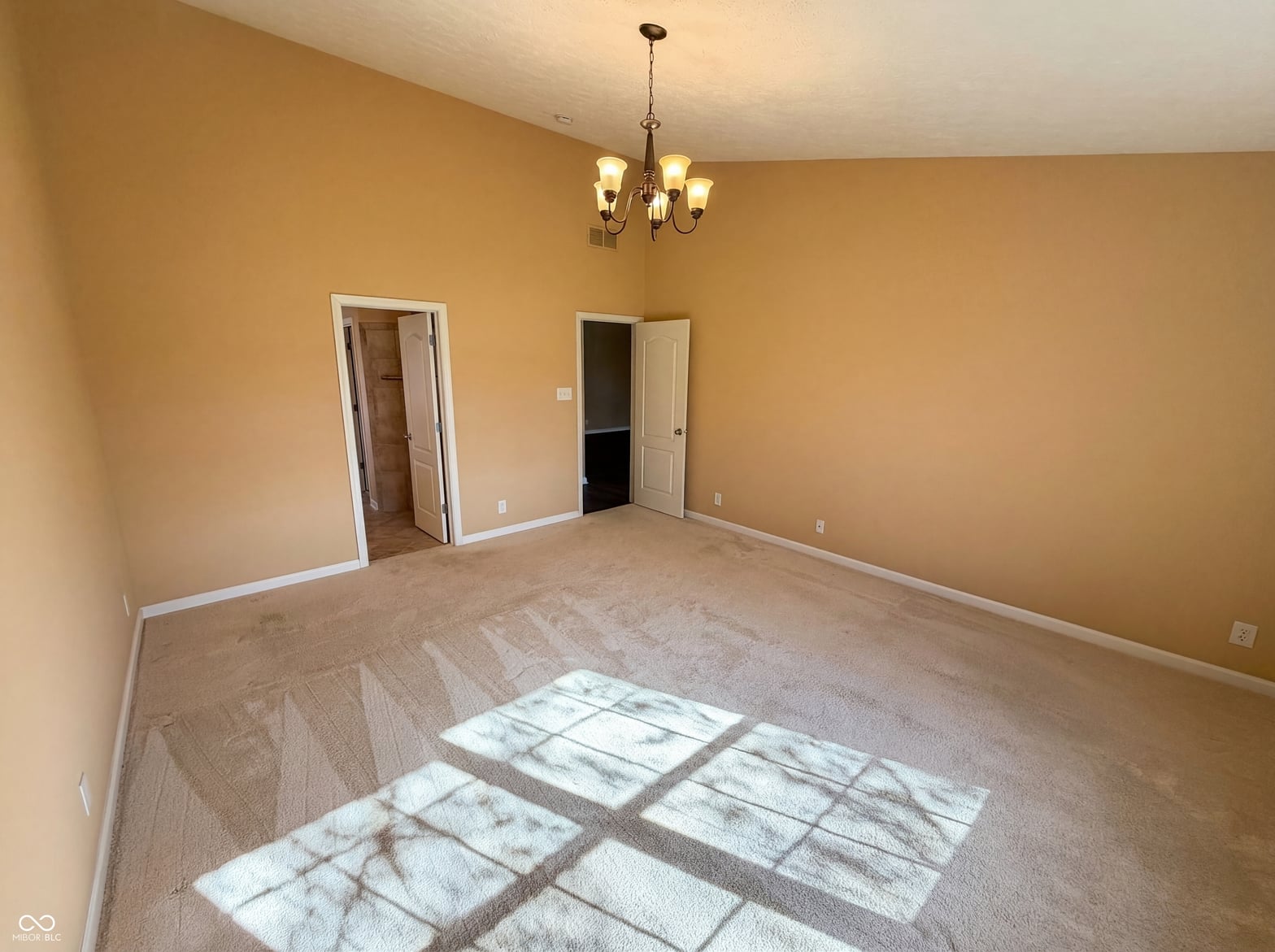 Spacious primary bedroom with dual closets and natural light