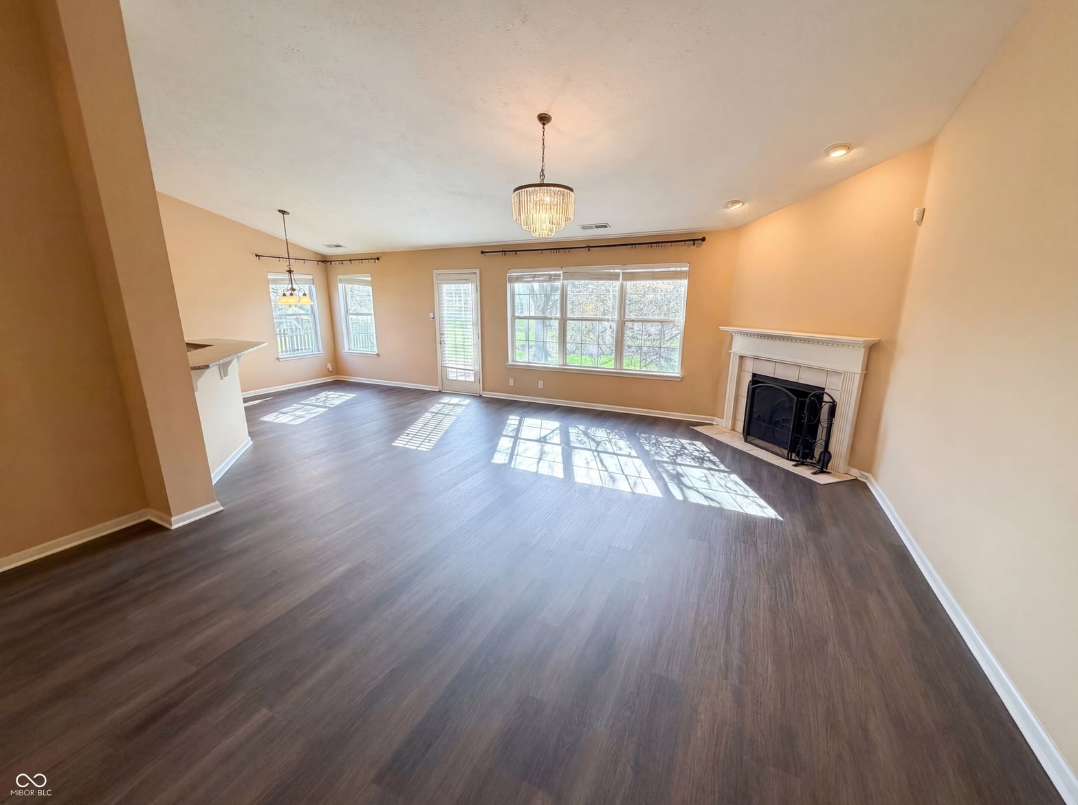 Bright, spacious living room with fireplace and hardwood floors.