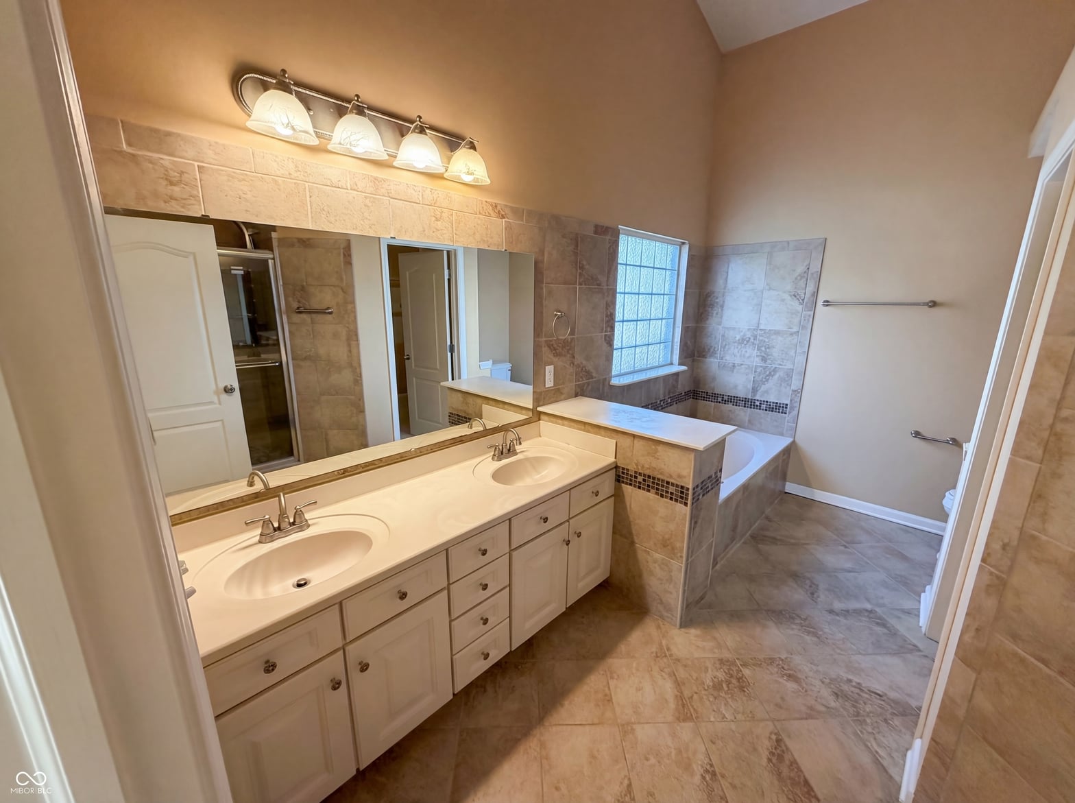 Spacious primary bath with dual vanity and soaking tub.