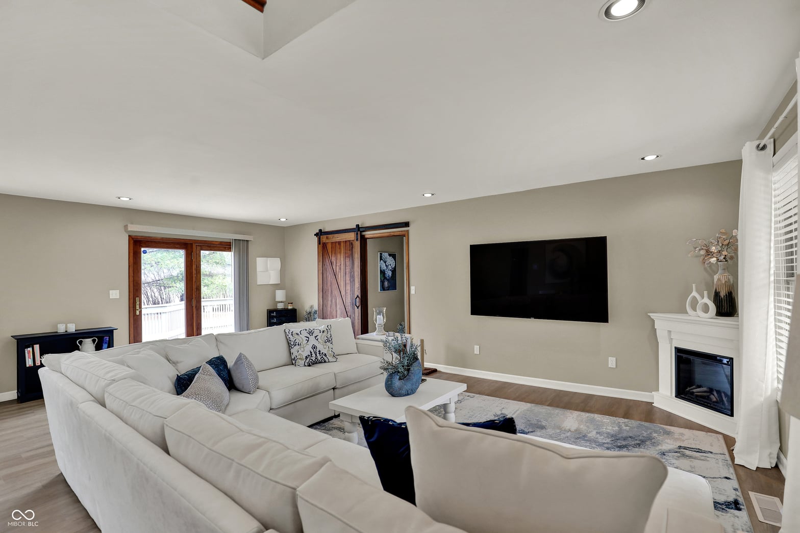 Bright family room with fireplace and entertainment setup.