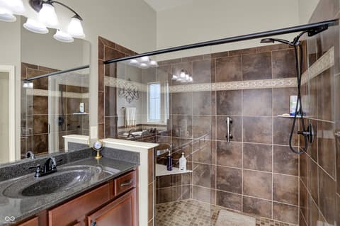 Primary bathroom at 10001 Copper Saddle Bend, Fishers, IN — Luxurious primary bath with spa-like walk-in shower.