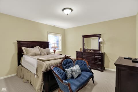 Primary bedroom at 10001 Copper Saddle Bend, Fishers, IN — Spacious primary bedroom with elegant dark wood furnishings.