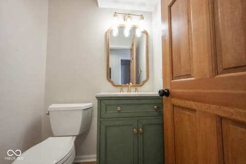 Bathroom at 72 Ashbourne Drive, Noblesville, IN — Stylish bathroom with green vanity and marble countertop.
