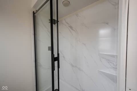 Primary bathroom at 72 Ashbourne Drive, Noblesville, IN — Luxe marble shower with frameless glass enclosure.