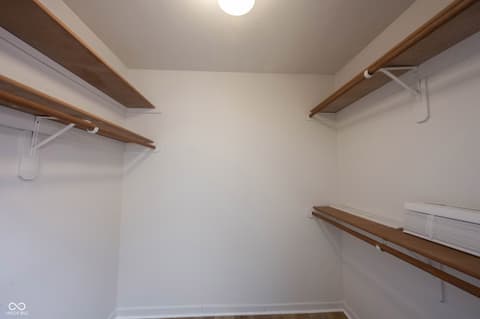Primary bedroom at 72 Ashbourne Drive, Noblesville, IN — Spacious walk-in closet with organized wooden shelving.