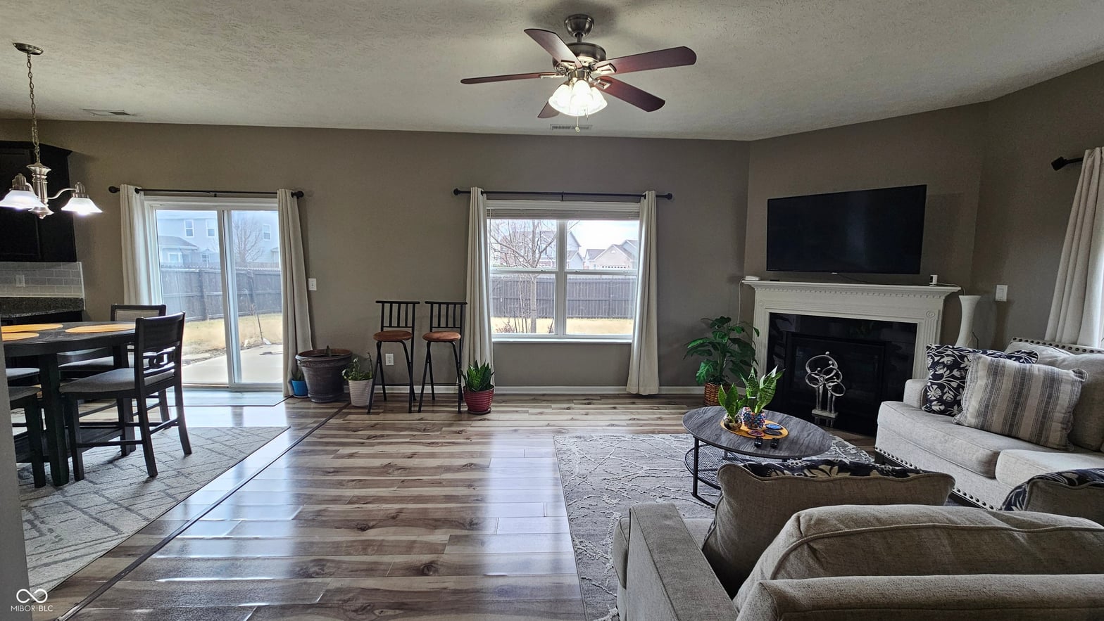 Spacious open-concept living with fireplace and natural light.