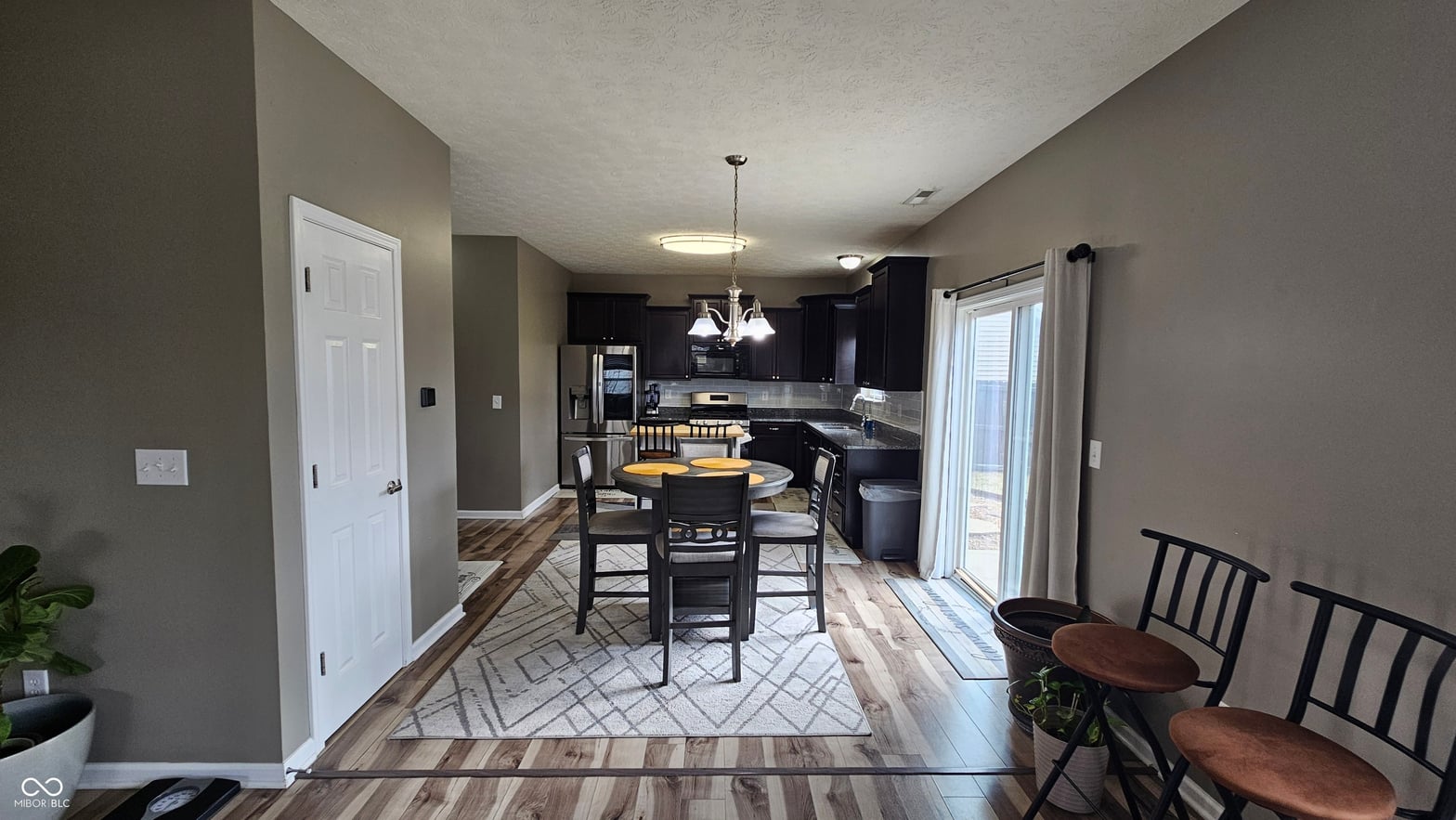 Modern kitchen with dark cabinets and open floor plan.