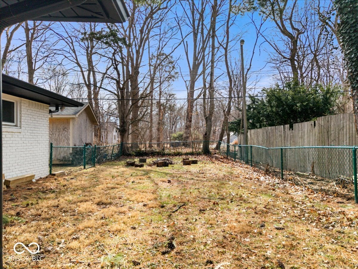 Spacious fenced yard with mature trees and privacy.