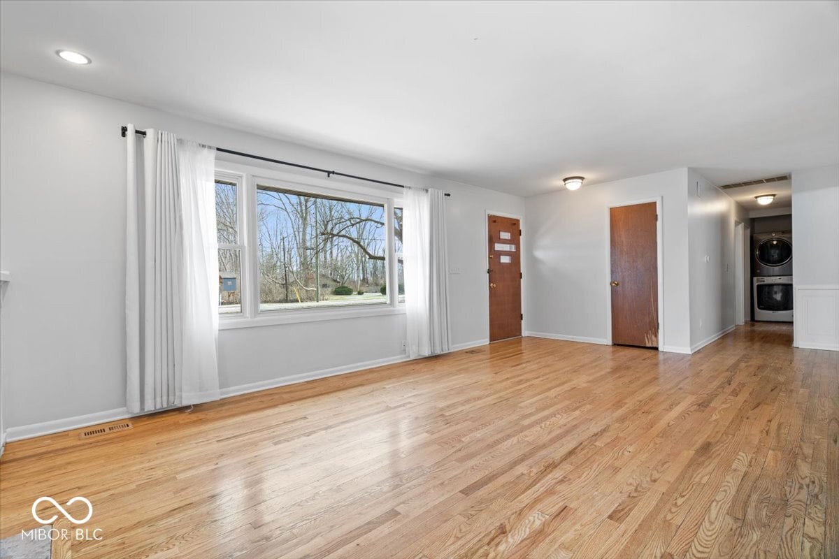 Bright living room with hardwood floors and expansive windows.