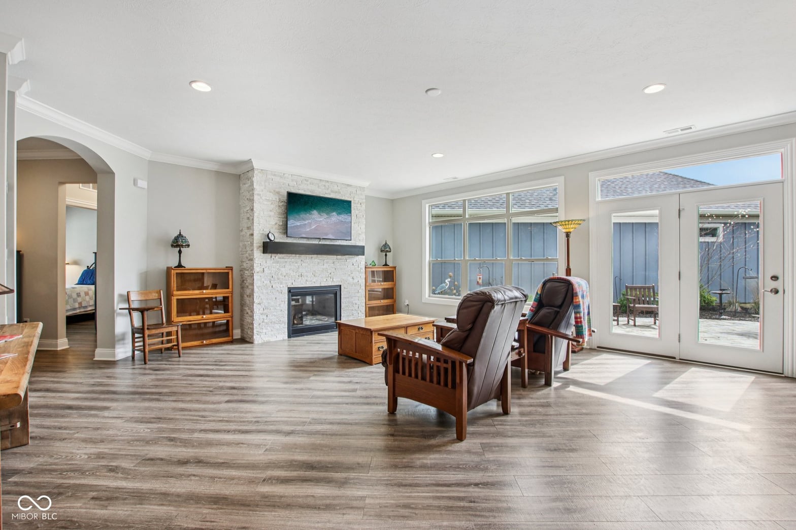 Bright open living room with fireplace and patio access.