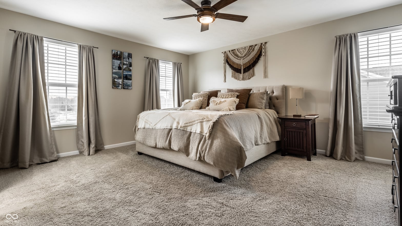 Bright primary bedroom with multiple windows and updated finishes.