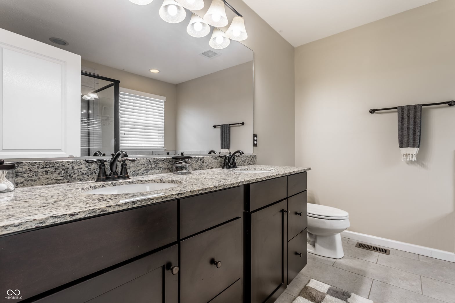 Spacious primary bath with dual vanity and granite counters.