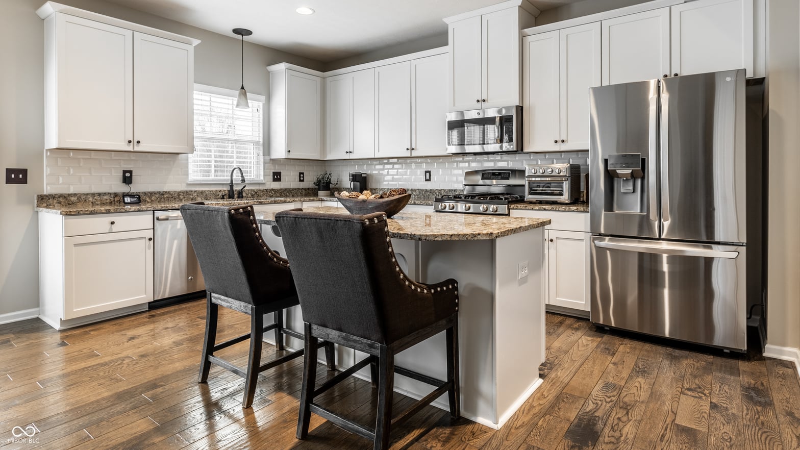Modern updated kitchen with granite island and stainless appliances.
