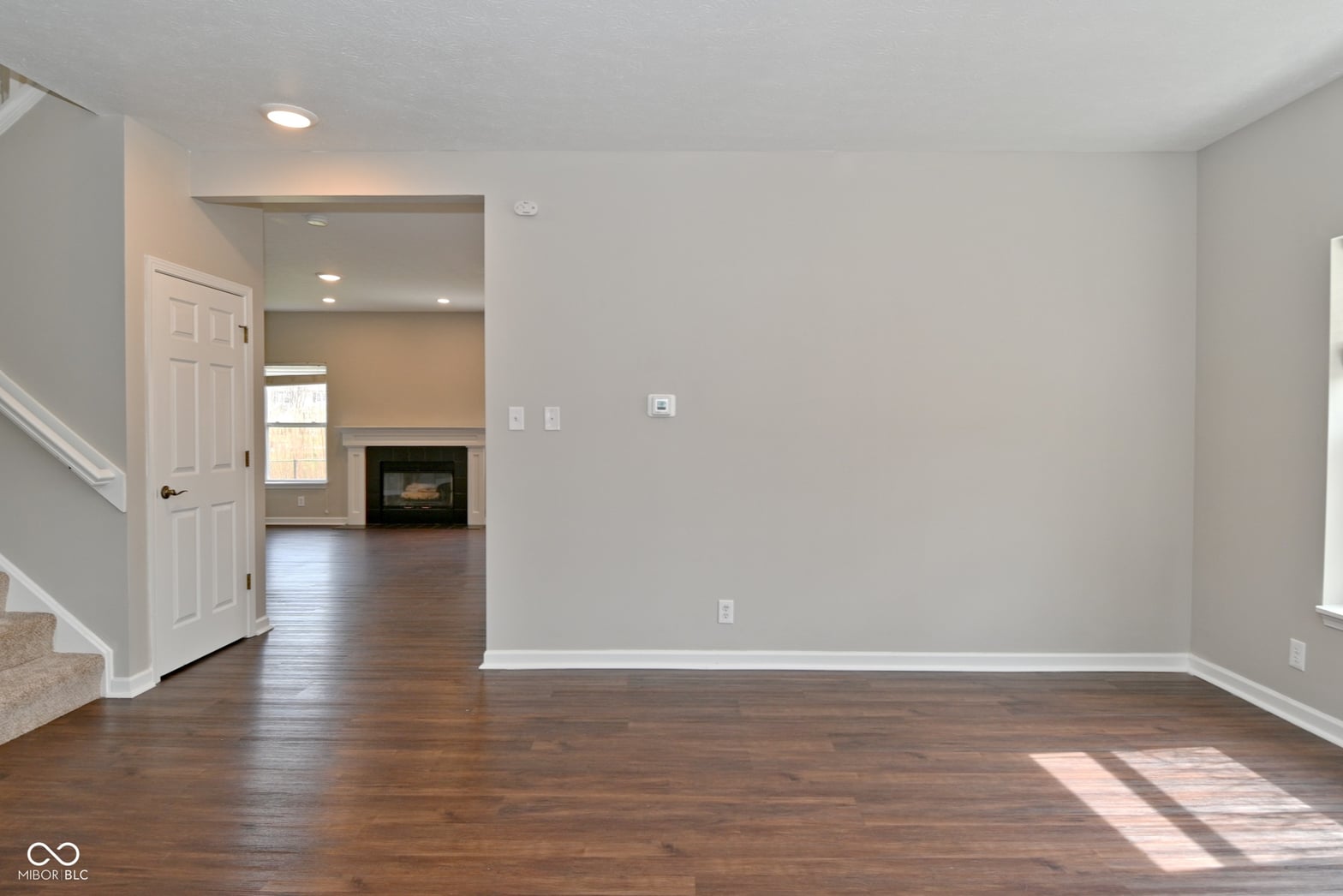 Spacious family room with fireplace and hardwood floors.