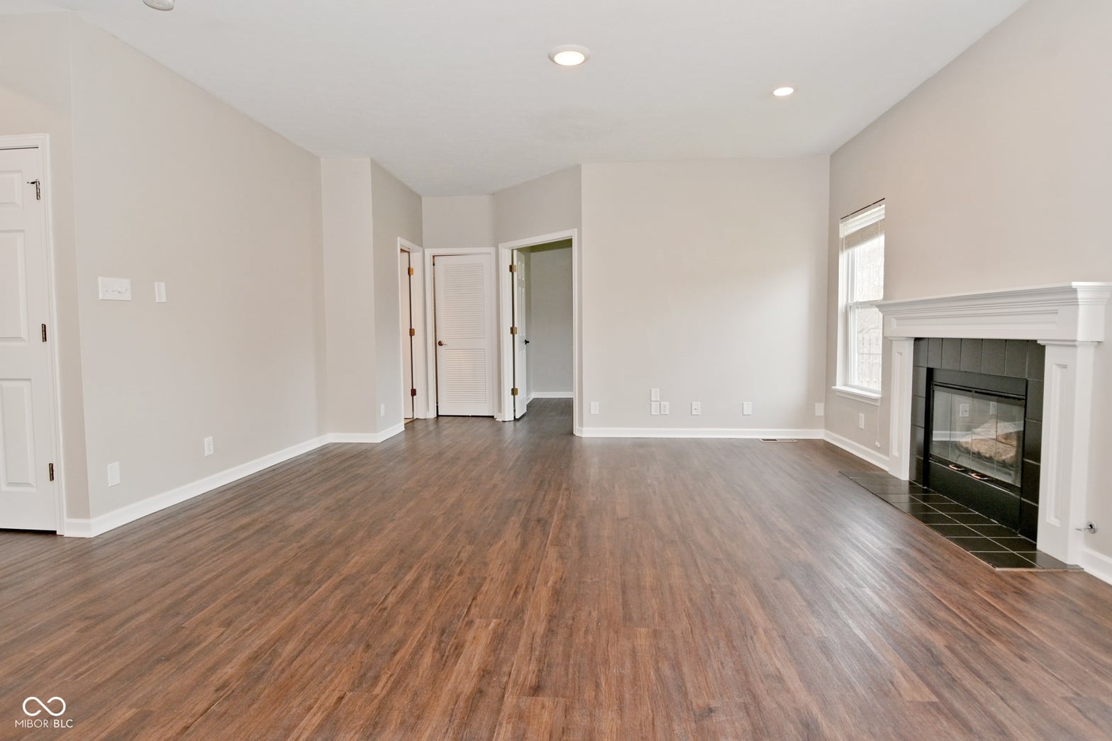 Spacious living room with fireplace and gleaming hardwood floors.