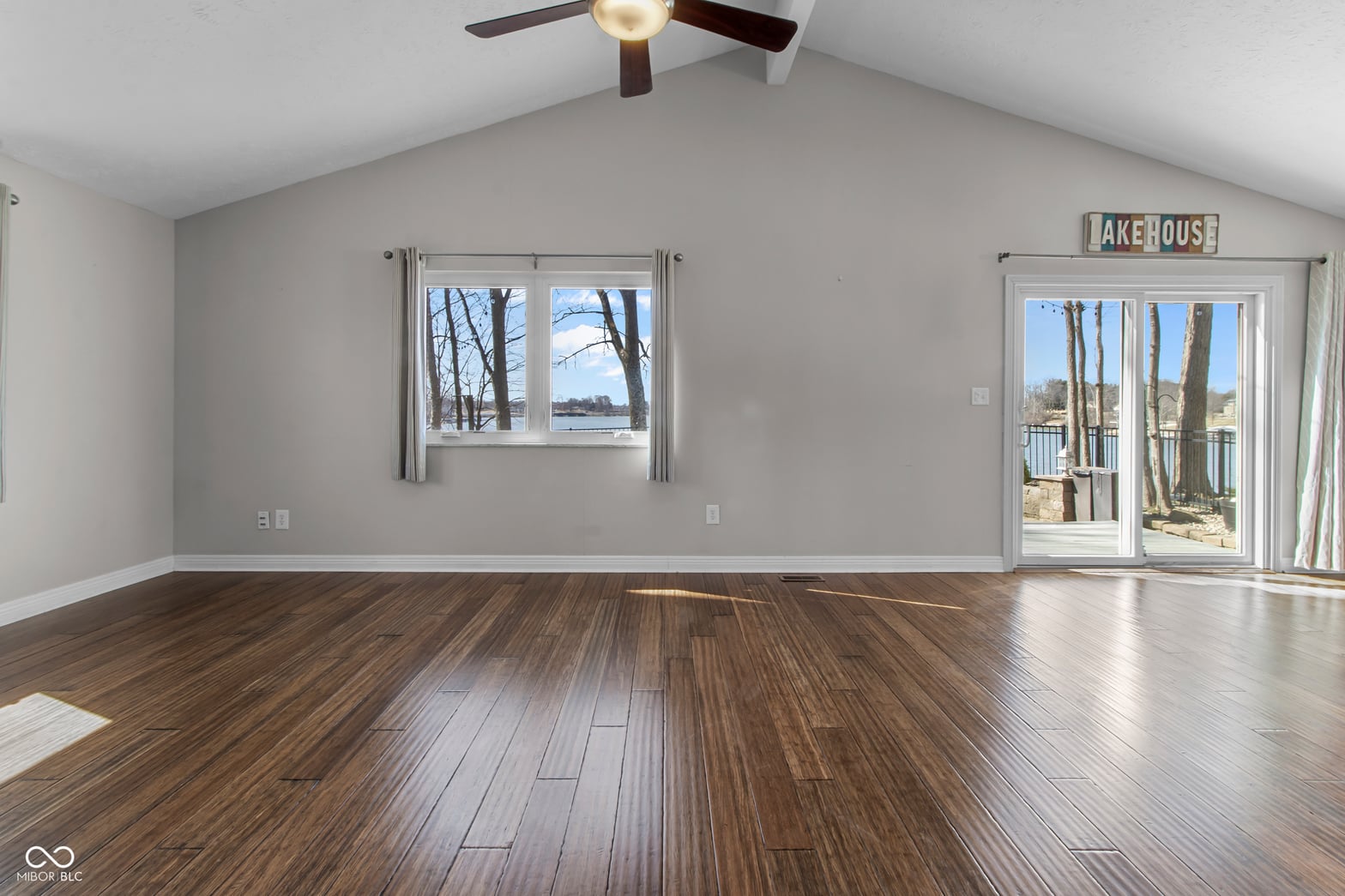 Spacious room with water views and hardwood floors.