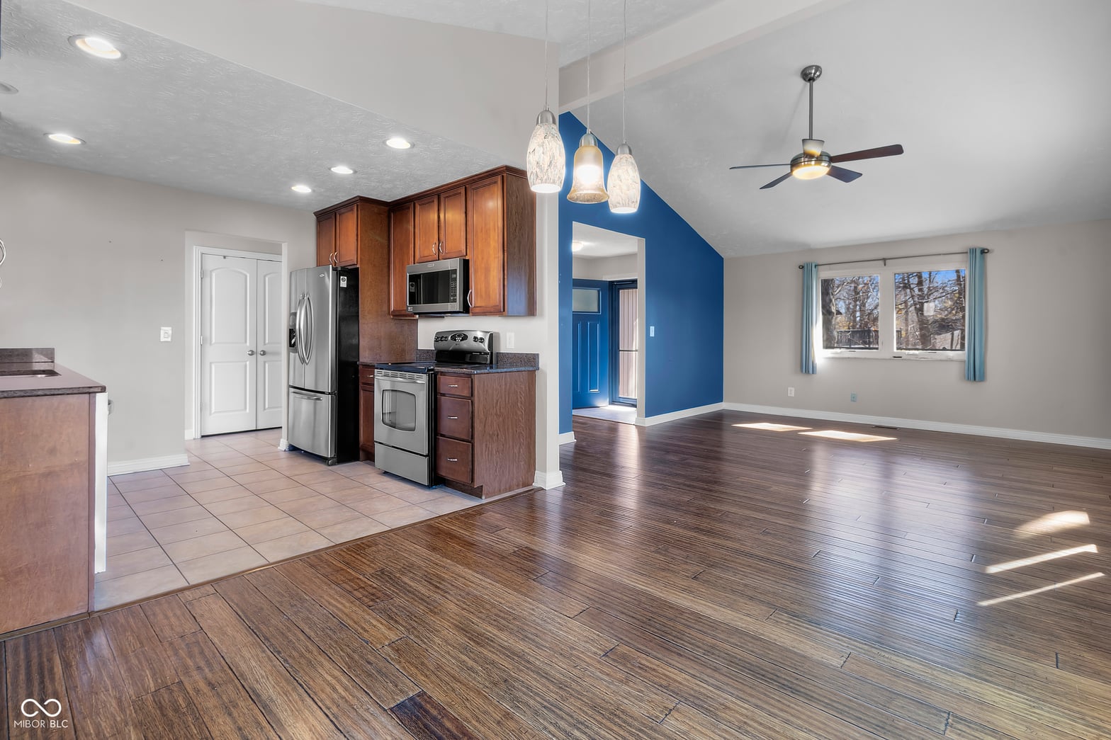 Modern kitchen flows into bright open living space.