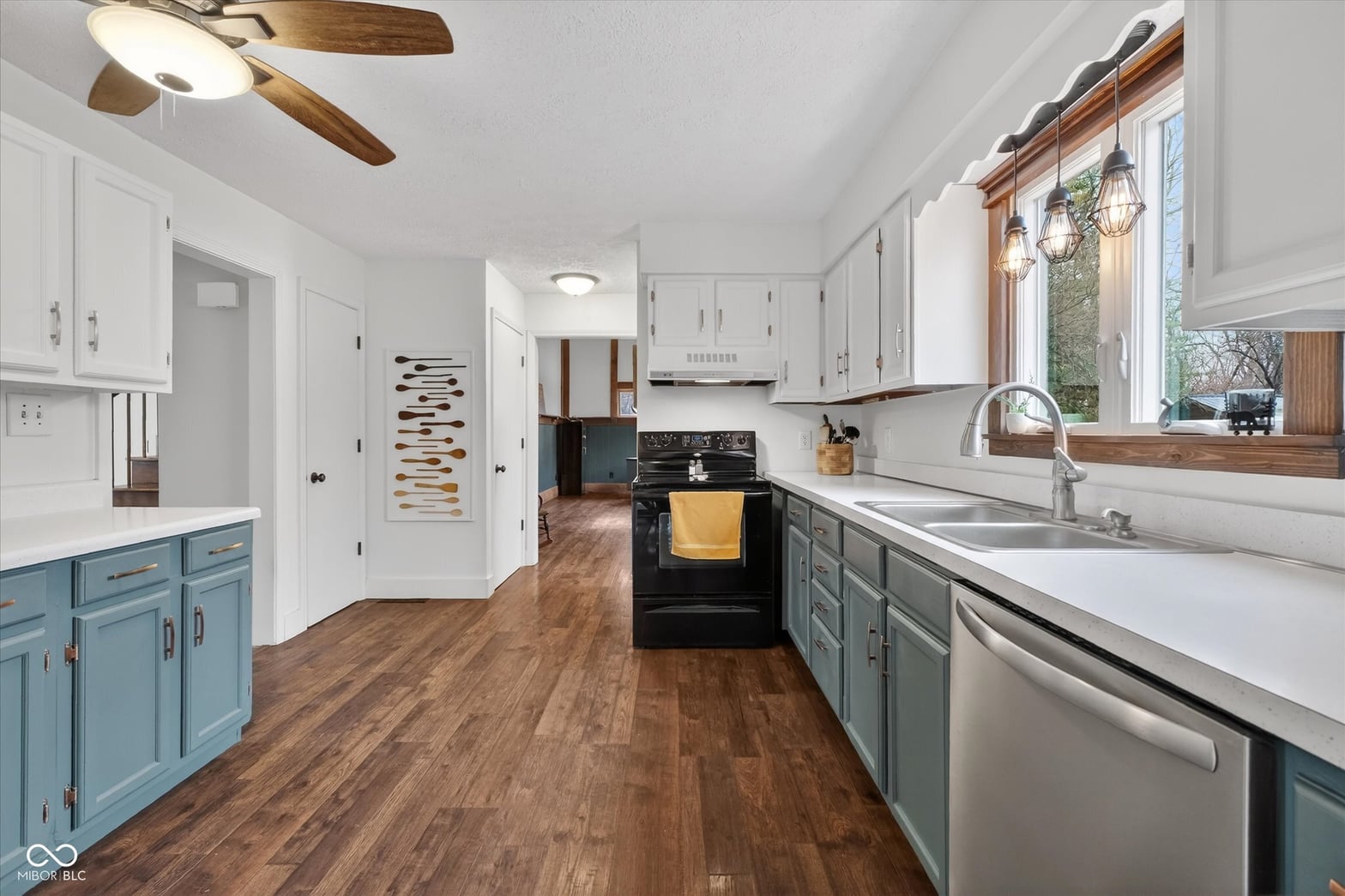 Bright, updated kitchen with mixed cabinetry and modern appliances.