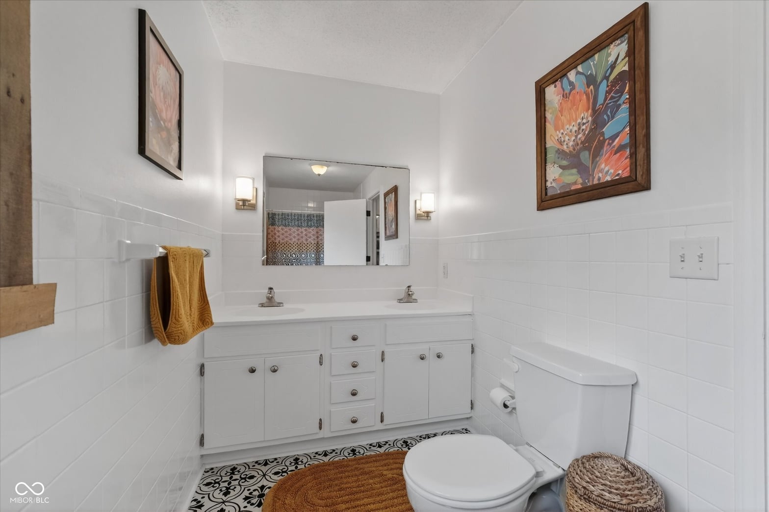 Bright, updated primary bath with dual vanity and modern finishes.