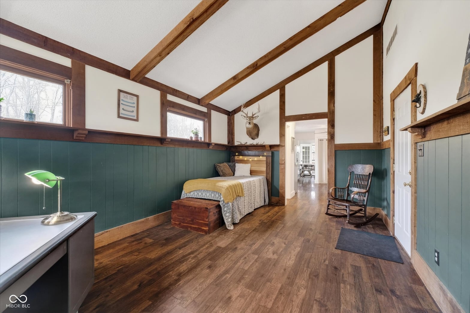 Spacious primary bedroom with soaring beamed ceilings and custom finishes.