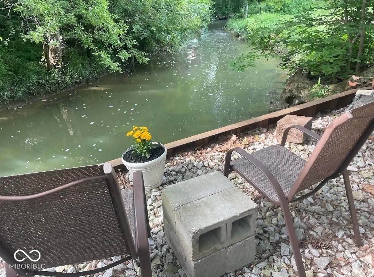 Peaceful riverside patio with lush tree canopy views.