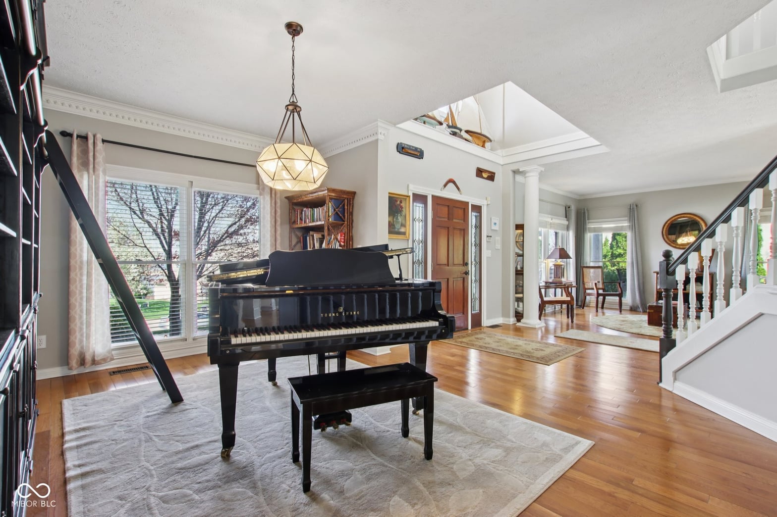 Elegant living room with grand piano and abundant natural light.