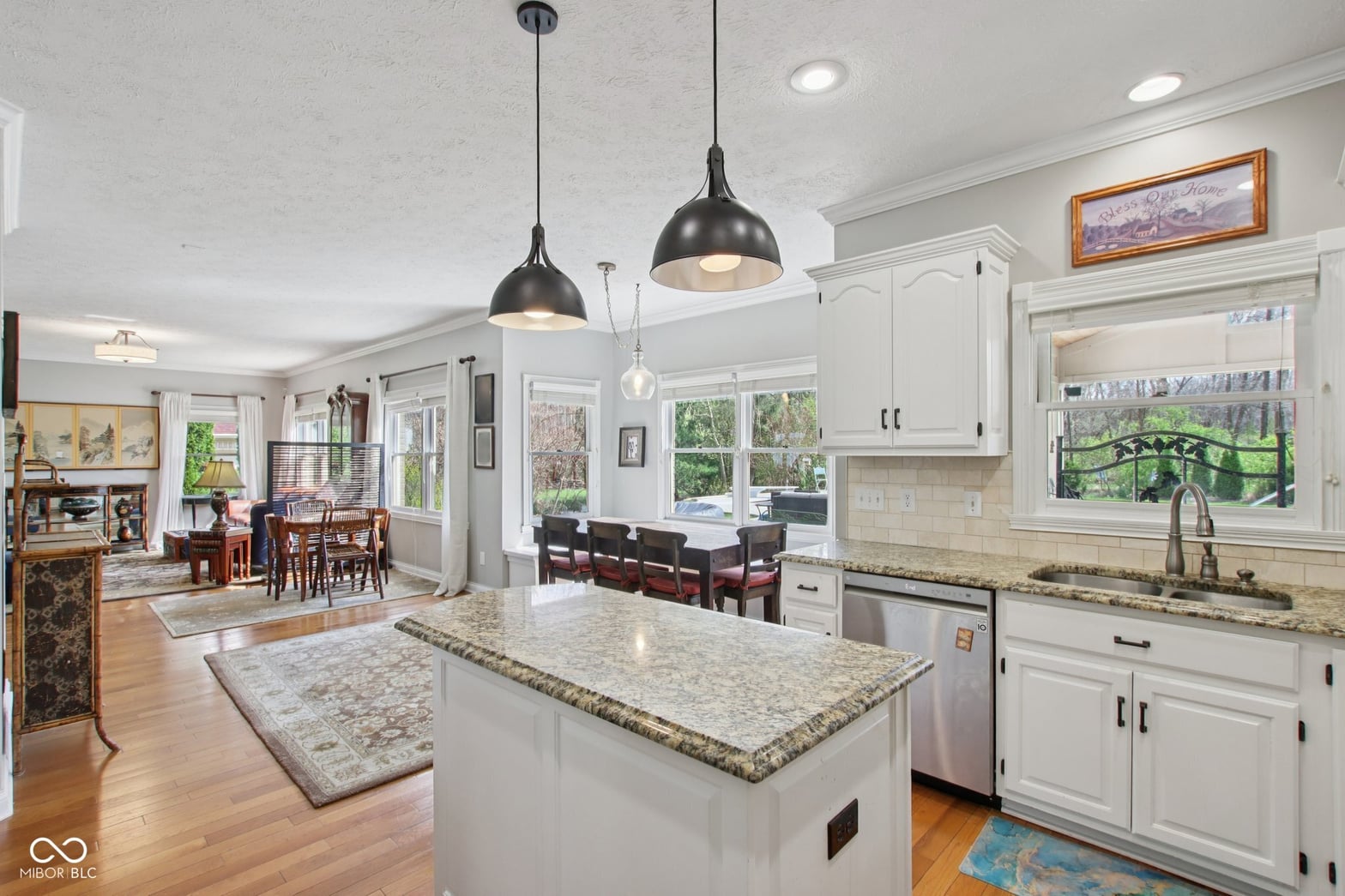 Bright renovated kitchen with granite island and modern finishes.